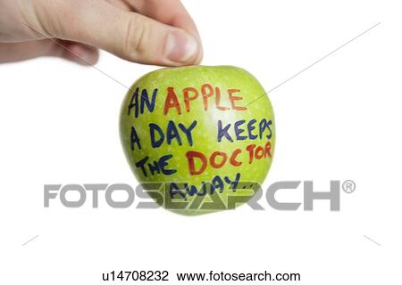 Stock Image - Cropped image of hand holding a granny smith apple with sayings text over white background. Fotosearch