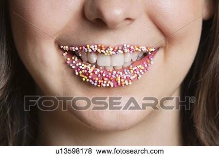 Stock Photo - Cropped portrait of Middle Eastern woman with sprinkle candy lips. Fotosearch