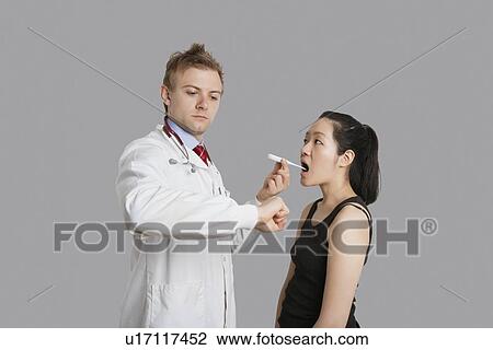 Doctor checking temperature of female patient View Large Photo Image Stock Image - Doctor checking temperature of female patient. Fotosearch