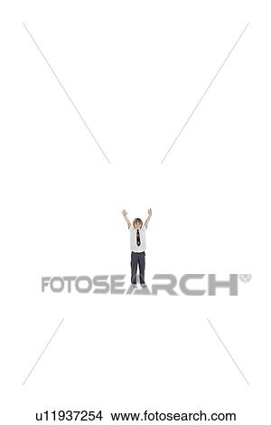 Picture - Elementary boy standing at distance with arms raised over white background. Fotosearch