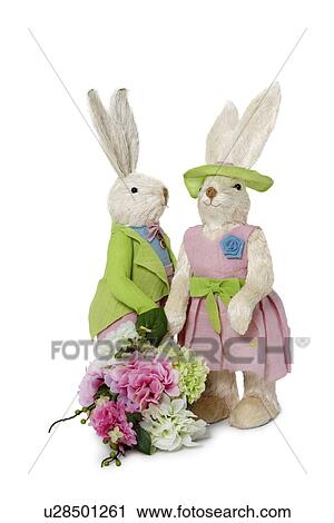 Stock Image - Female and male Rabbits with flower bouquet standing over white background. Fotosearch