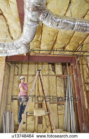 Female architect moving up the ladder to check incomplete ceiling View Large Photo Image Picture - Female architect moving up the ladder to check incomplete ceiling. Fotosearch