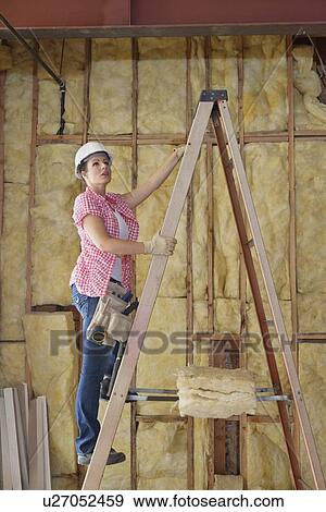 Female contractor climbing up the ladder at construction site View Large Photo Image Stock Photo - Female contractor climbing up the ladder at construction site. Fotosearch