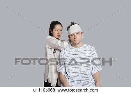 Female doctor dressing patient's head with bandage View Large Photo Image Stock Photo - Female doctor dressing patient's head with bandage. Fotosearch