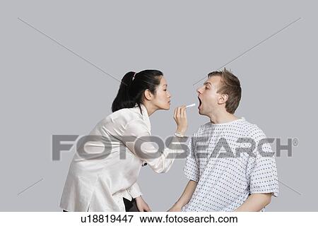 Female doctor examines patient's throat View Large Photo Image Stock Photo - Female doctor examines patient's throat. Fotosearch
