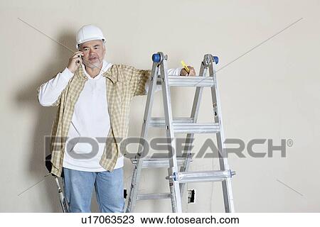 Front view of architect talking on mobile phone View Large Photo Image Stock Image - Front view of architect talking on mobile phone. Fotosearch