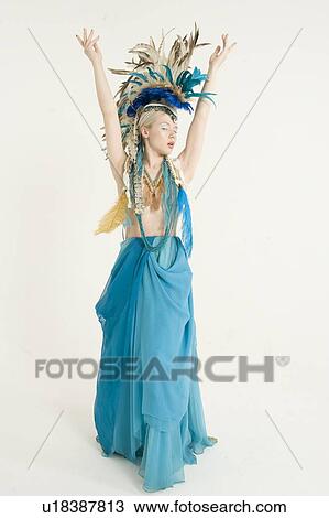 Stock Image - Front view of beautiful young woman with arms raised over colored background. Fotosearch