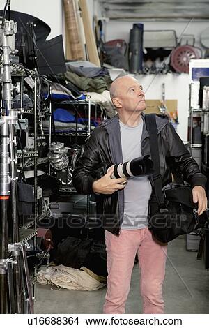 Front view of senior photographer looking up in studio View Large Photo Image Picture - Front view of senior photographer looking up in studio. Fotosearch