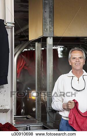 Stock Photo - Half-length portrait of happy car wash owner. Fotosearch