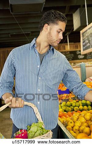 Handsome young man shopping in market View Large Photo Image Stock Photo - Handsome young man shopping in market. Fotosearch