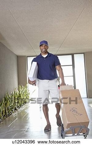 Stock Photograph - Happy African American delivery man with packages. Fotosearch