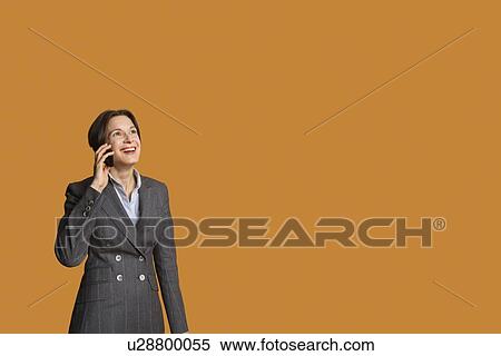 Stock Photography - Happy mid adult woman talking on mobile phone. Fotosearch