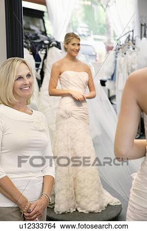 Happy mother admiring daughter dressed in a wedding gown View Large Photo Image Picture - Happy mother admiring daughter dressed in a wedding gown. Fotosearch