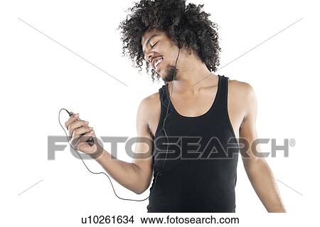Picture - Happy young man listening to mp3 player over white background. Fotosearch