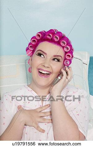 Happy young woman talking on mobile phone with hair curlers View Large Photo Image Stock Photograph - Happy young woman talking on mobile phone with hair curlers. Fotosearch