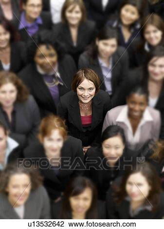 Stock Image - High angle view of a businesswoman standing amidst multiethnic businesspeople. Fotosearch