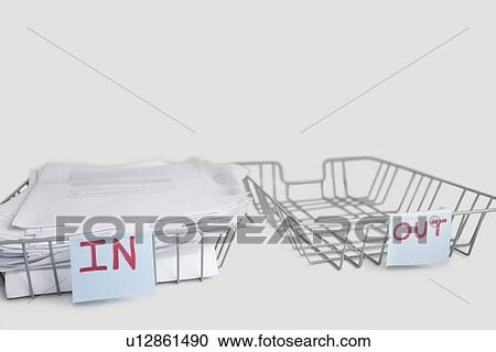 Stock Image - In and out desk trays in an office over white background. Fotosearch