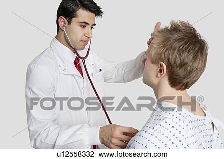 Indian doctor examining male patient with stethoscope View Large Photo Image Stock Image - Indian doctor examining male patient with stethoscope. Fotosearch