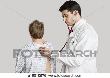 Indian doctor examining male patient View Large Photo Image Stock Photograph - Indian doctor examining male patient. Fotosearch