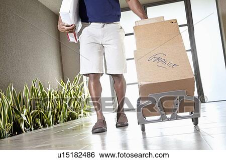 Low section of a man walking with packages on handtruck View Large Photo Image Stock Photograph - Low section of a man walking with packages on handtruck. Fotosearch