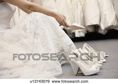 Low section of woman sitting with variety of footwear in bridal boutique View Large Photo Image Stock Photo - Low section of woman sitting with variety of footwear in bridal boutique. Fotosearch