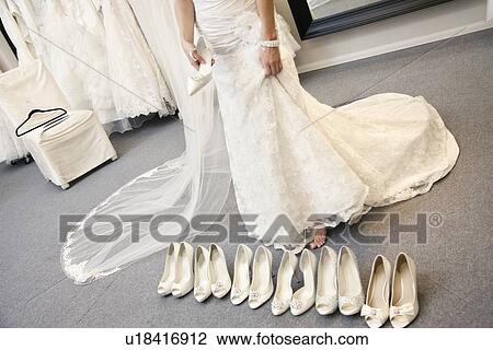 Low section of young woman standing with variety of footwear in bridal boutique View Large Photo Image Stock Image - Low section of young woman standing with variety of footwear in bridal boutique. Fotosearch