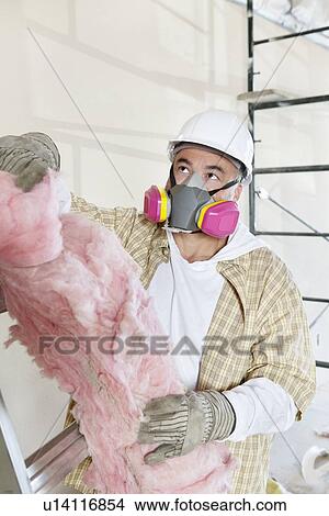 Male contractor wearing dust mask while holding sponge at construction site View Large Photo Image Picture - Male contractor wearing dust mask while holding sponge at construction site. Fotosearch