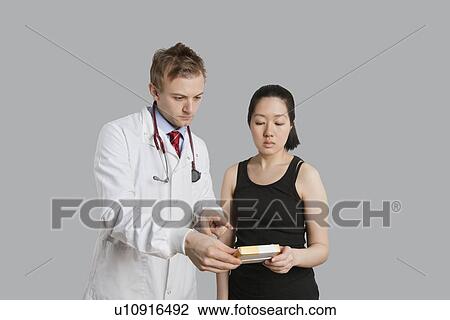 Male doctor suggesting medication to female patient View Large Photo Image Stock Image - Male doctor suggesting medication to female patient. Fotosearch