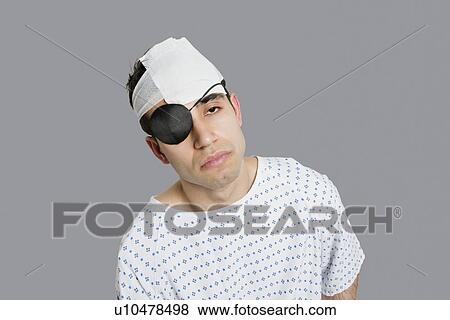 Male patient wearing an eye patch suffering from head injury View Large Photo Image Stock Photo - Male patient wearing an eye patch suffering from head injury. Fotosearch