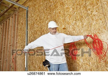 Mature male construction worker with an electrical wire View Large Photo Image Stock Image - Mature male construction worker with an electrical wire. Fotosearch