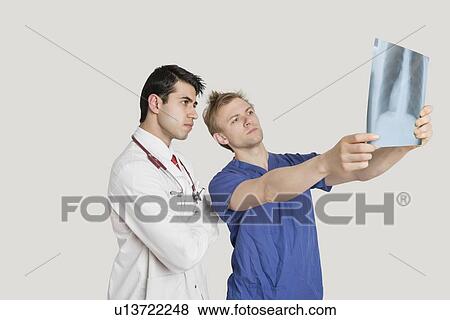 Stock Photo - Medical professionals looking at chest x-ray over light gray background. Fotosearch