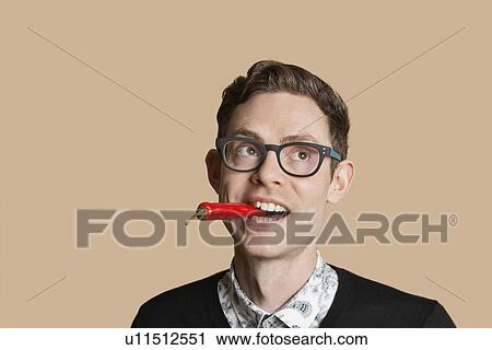 Mid adult man with red chili pepper while looking away over colored background View Large Photo Image Stock Image - Mid adult man with red chili pepper while looking away over colored background. Fotosearch