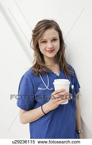 Portrait of a beautiful female doctor holding a disposable cup over colored background View Large Photo Image Stock Photography - Portrait of a beautiful female doctor holding a disposable cup over colored background. Fotosearch