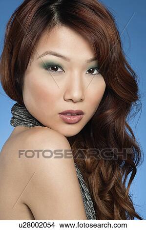 Picture - Portrait of a beautiful young Asian woman over colored background. Fotosearch