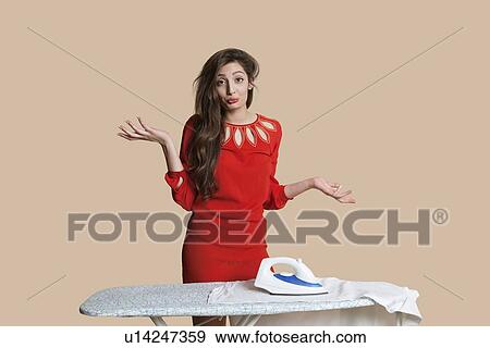 Portrait of a beautiful young woman shrugging shoulders over colored background View Large Photo Image Stock Photo - Portrait of a beautiful young woman shrugging shoulders over colored background. Fotosearch