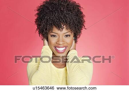 Portrait of a cheerful African American woman with hands over ears View Large Photo Image Stock Photograph - Portrait of a cheerful African American woman with hands over ears. Fotosearch