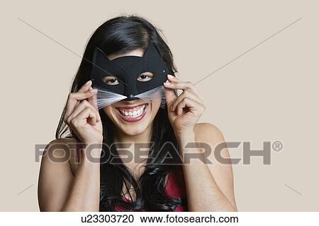 Portrait of a cheerful young woman wearing eye mask over colored background View Large Photo Image Stock Image - Portrait of a cheerful young woman wearing eye mask over colored background. Fotosearch