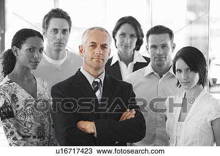 Portrait of a confident businessman standing arms crossed with office workers View Large Photo Image Stock Image - Portrait of a confident businessman standing arms crossed with office workers. Fotosearch