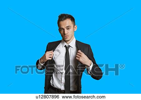 Portrait of a confident young businessman over colored background View Large Photo Image Stock Photograph - Portrait of a confident young businessman over colored background. Fotosearch