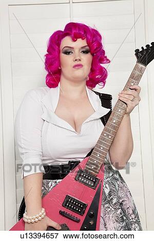 Stock Photo - Portrait of a confident young woman with guitar. Fotosearch