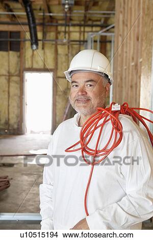 Picture - Portrait of a construction worker with a red electric wire. Fotosearch