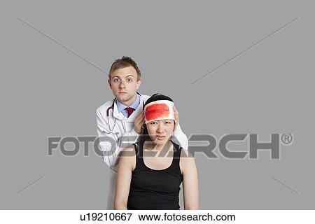 Portrait of a doctor treating his female patient View Large Photo Image Stock Photo - Portrait of a doctor treating his female patient. Fotosearch