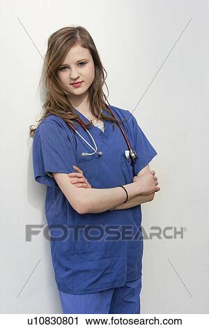 Portrait of a female surgeon standing with arms crossed over colored background View Large Photo Image Stock Image - Portrait of a female surgeon standing with arms crossed over colored background. Fotosearch