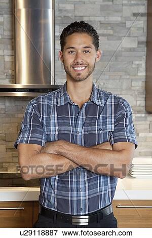 Stock Photo - Portrait of a handsome young man with arms crossed. Fotosearch