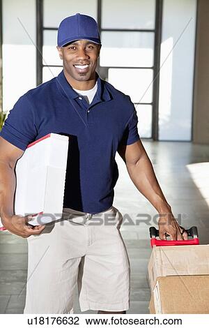 Portrait of a happy African American man carrying delivery boxes View Large Photo Image Stock Image - Portrait of a happy African American man carrying delivery boxes. Fotosearch