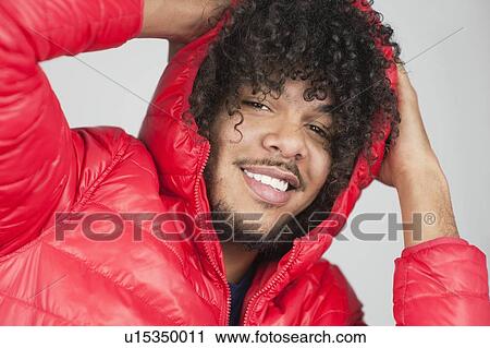 Portrait of a happy curly haired man with hands behind head over colored background View Large Photo Image Stock Image - Portrait of a happy curly haired man with hands behind head over colored background. Fotosearch