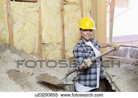 Portrait of a happy female contractor digging sand at construction site View Large Photo Image Stock Photography - Portrait of a happy female contractor digging sand at construction site. Fotosearch