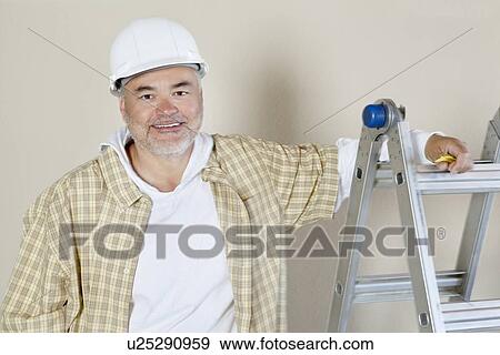 Portrait of a happy male contractor over colored background View Large Photo Image Stock Photo - Portrait of a happy male contractor over colored background. Fotosearch