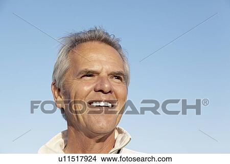 Portrait of a happy mature man over blue sky View Large Photo Image Picture - Portrait of a happy mature man over blue sky. Fotosearch