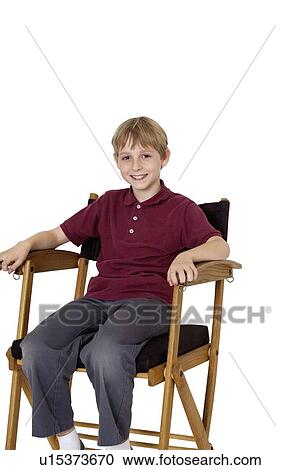 Portrait of a happy pre-teen boy sitting on director's chair over white background View Large Photo Image Stock Image - Portrait of a happy pre-teen boy sitting on director's chair over white background. Fotosearch